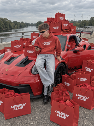 Levi on a red GT3 RS surrounded by Launch Club bags